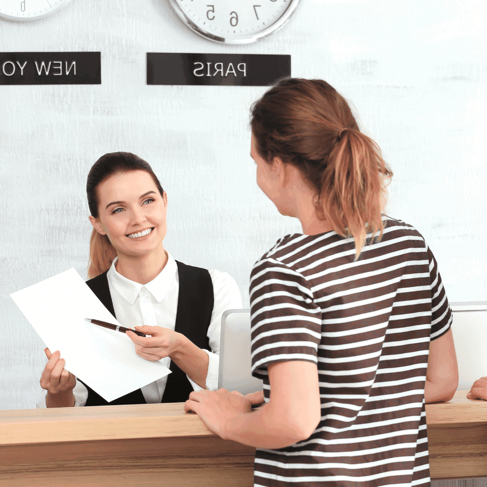 Réceptionniste accueillante à l'hôtel avec cliente.