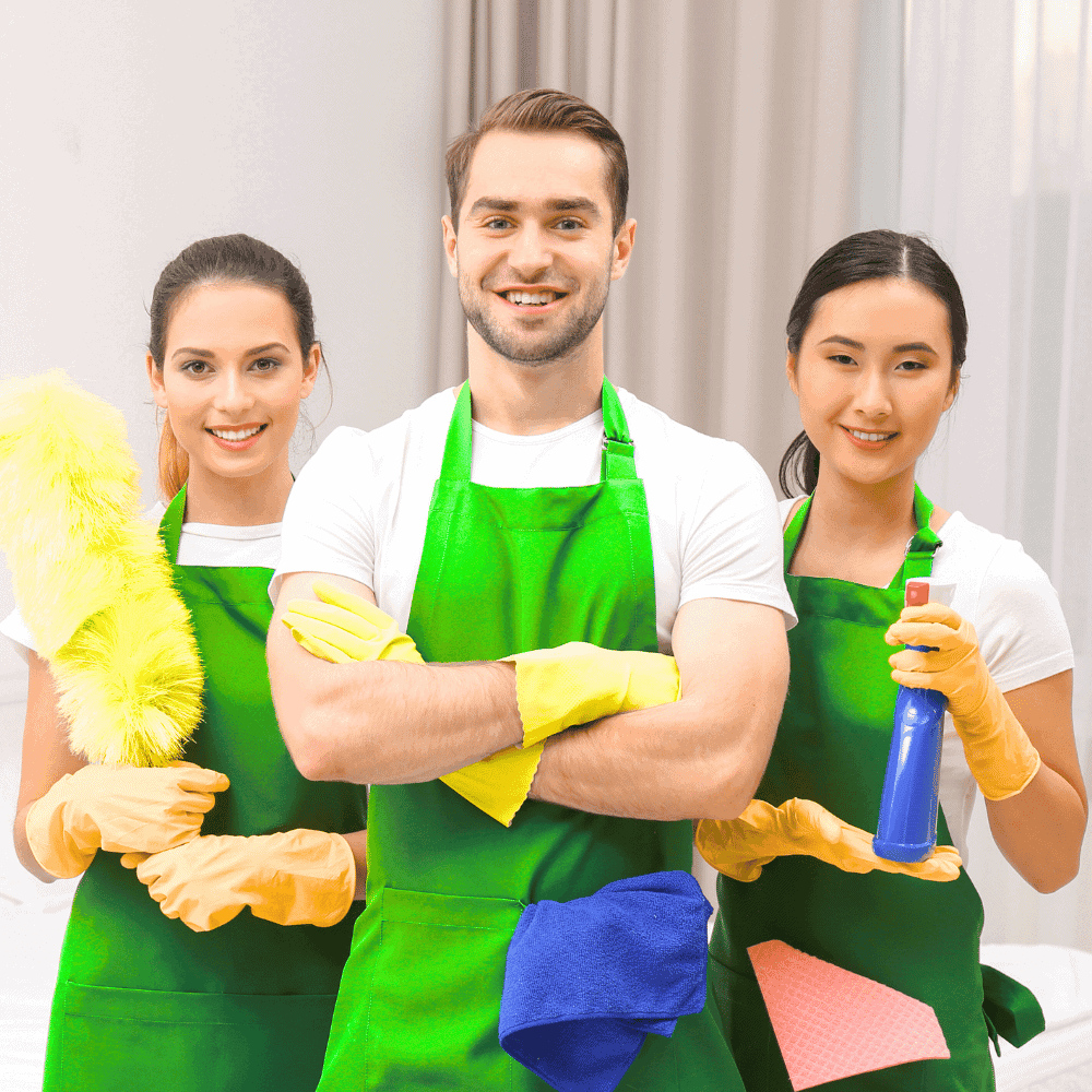 Équipe de nettoyage souriante avec produits.