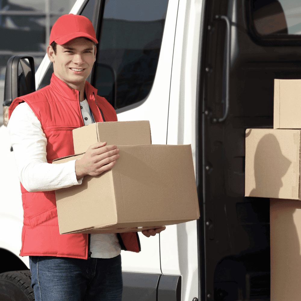 Delivery man carrying boxes to a van.