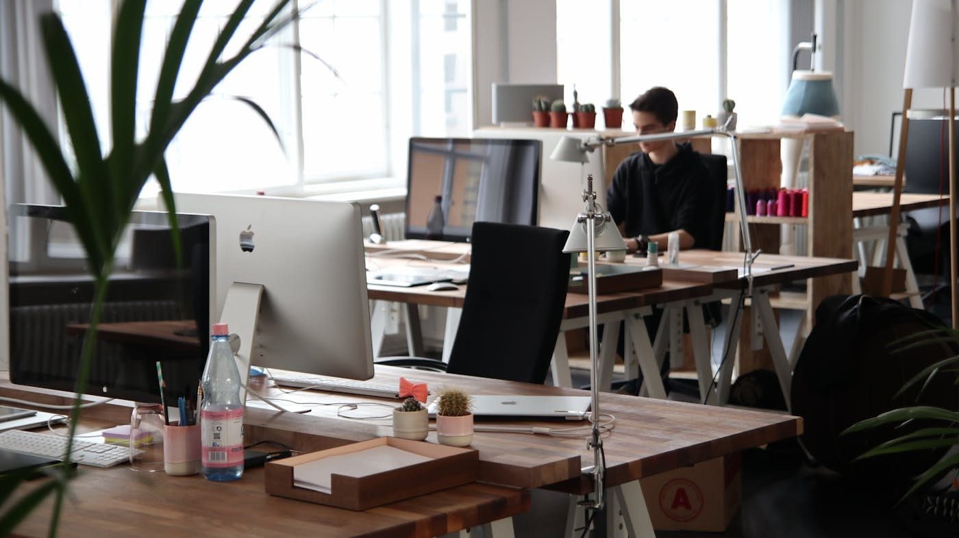 Employé concentré travaillant dans un espace de bureau lumineux et moderne.