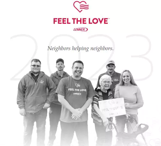 A group of six people, including an elderly woman holding a certificate, stand in front of a "Feel the Love" and "Neighbors helping neighbors" backdrop.