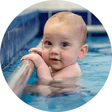 Baby Holding Onto Rail On Side Of Swimming Pool