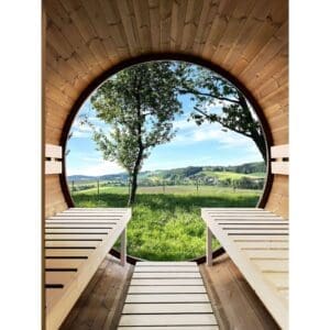 Vista interna di una sauna in legno con grande finestra rotonda che offre una vista su un paesaggio verde e collinare soleggiato.