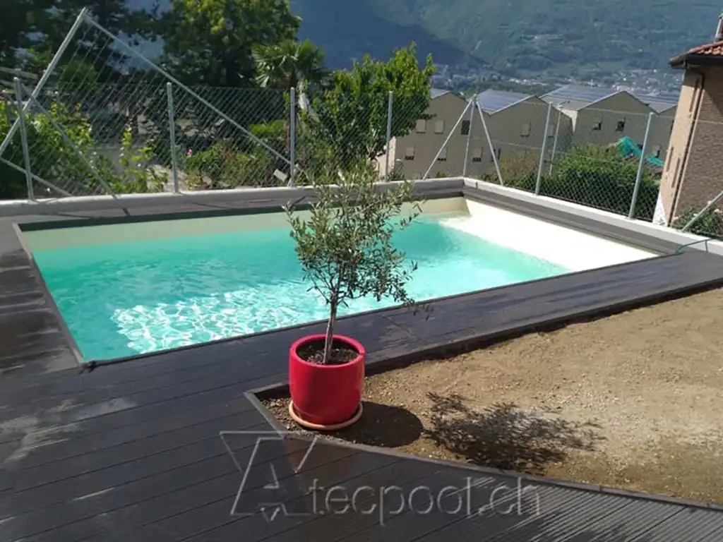 Piscina interrata a sfioro con vista panoramica sulle montagne circostanti.