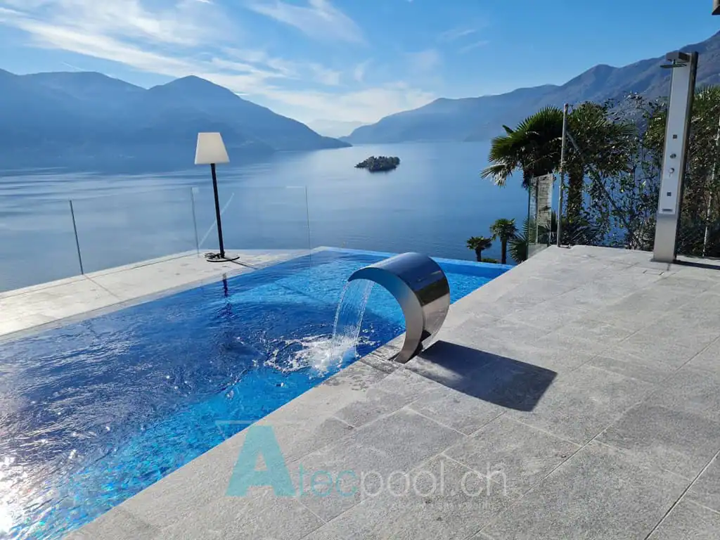 Balneare con piscina interrata a sfioro su vista lago e montagne, spazio wellness con design moderno e completa di getto d'acqua. Perfetta per relax e divertimento.