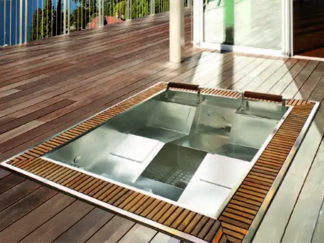 Vasca idromassaggio da incasso in acciaio inox su terrazza in legno con poggiatesta e sedute ergonomiche