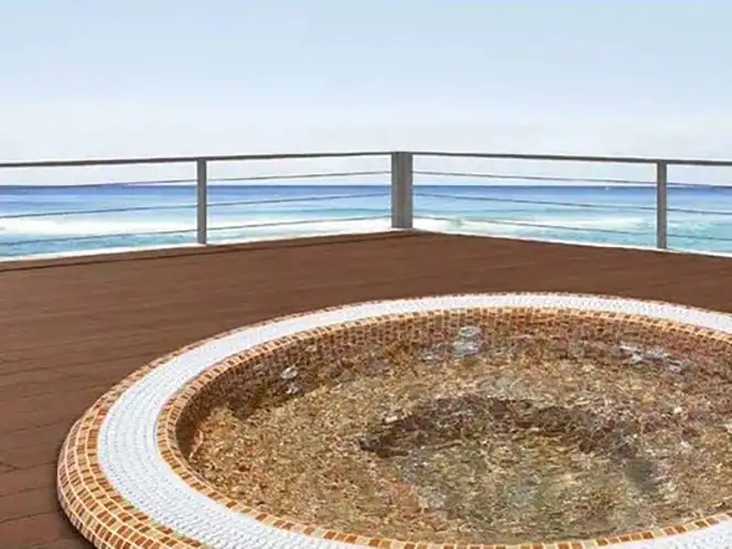 Vasca idromassaggio rotonda rivestita in mosaico, con vista mare da terrazza in legno