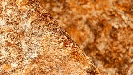 Una superficie rocciosa con tonalità calde che richiama un ambiente naturale e rilassante.