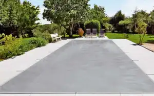 Piscina con copertura a rete grigia traspirante, fissata a bordo vasca per protezione invernale e sicurezza