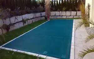 Piscina rettangolare con copertura a rete verde, soluzione leggera e resistente per protezione invernale