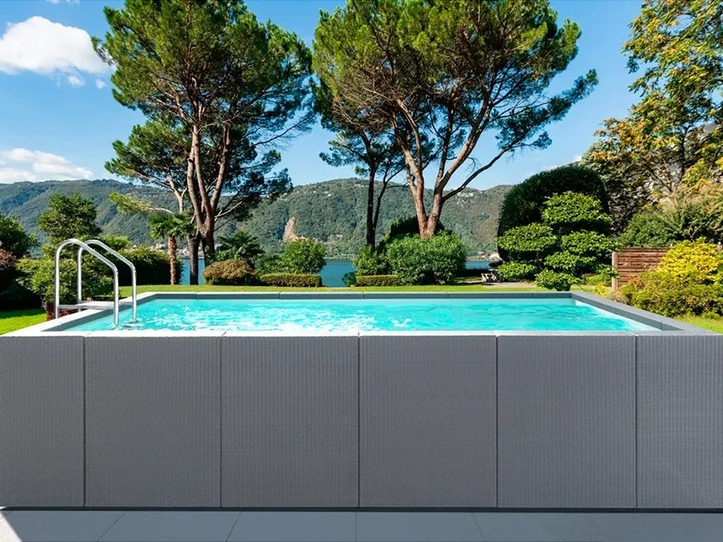 Piscina interrata con vista panoramica su natura e montagne circostanti.