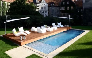 Piscina con Pooldeck in legno, copertura mobile che diventa terrazza con area relax e lettini prendisole