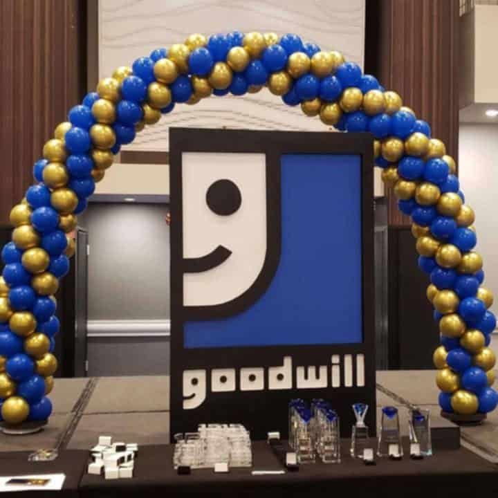 Balloons Arch Vibrant balloons arch featuring blue and gold at a Goodwill event, creating an inviting and festive atmosphere for community engagement.