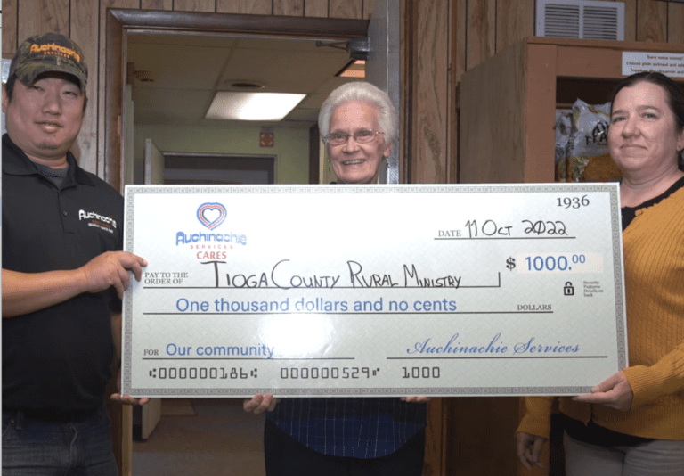 Three people proudly hold a $1,000 check from Auchinachie Services, dated October 19, 2022, made out to Tioga County Rural Ministry. This heartwarming gesture is what we're all about—community support and making meaningful contributions together.