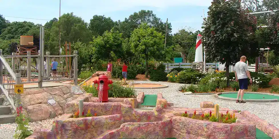 Miniature golf course featuring vibrant obstacles and lush greenery, perfect for family fun and outd.