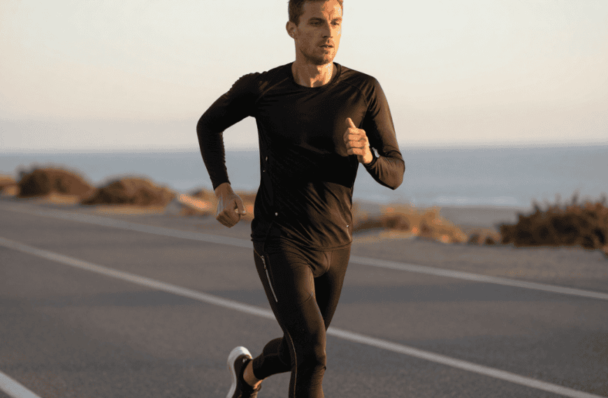 Homme courant sur la route près de la mer au coucher du soleil, pratique de la course à pied pour la.