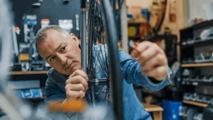 Fahrradmechaniker repariert ein Fahrrad in der Werkstatt.