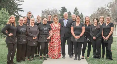 Cascades Manor staff team standing outdoors in front of a fence.