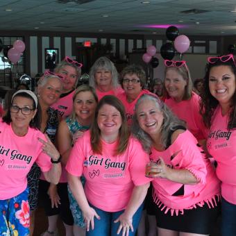 Group of women celebrating at Cascades Manor, wearing pink "Girl Gang" shirts.