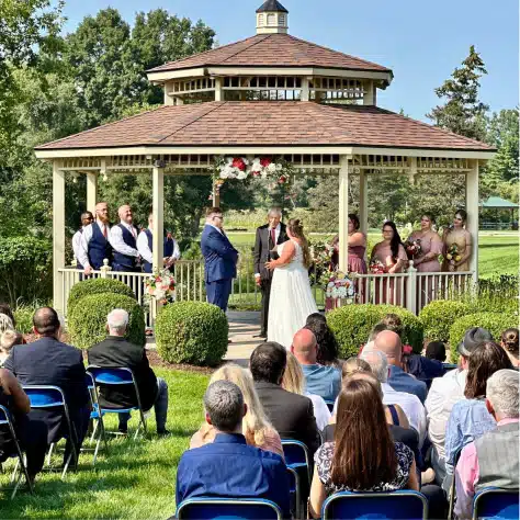 Gazebo wedding ceremony at Cascades Manor with guests and floral decor.
