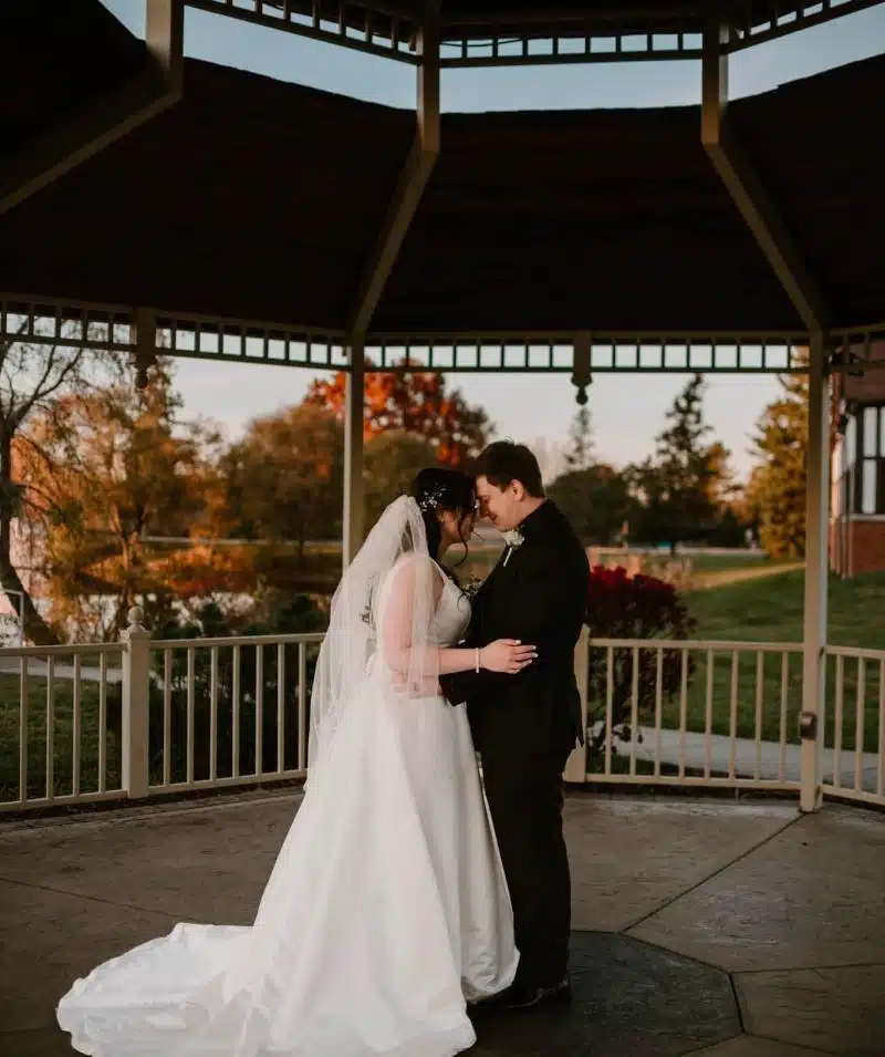 Bride and groom sharing a romantic moment in a scenic outdoor setting.