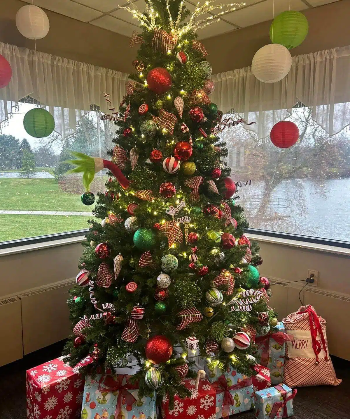 Christmas tree decorated with red, green, and silver ornaments at Cascades Manor.