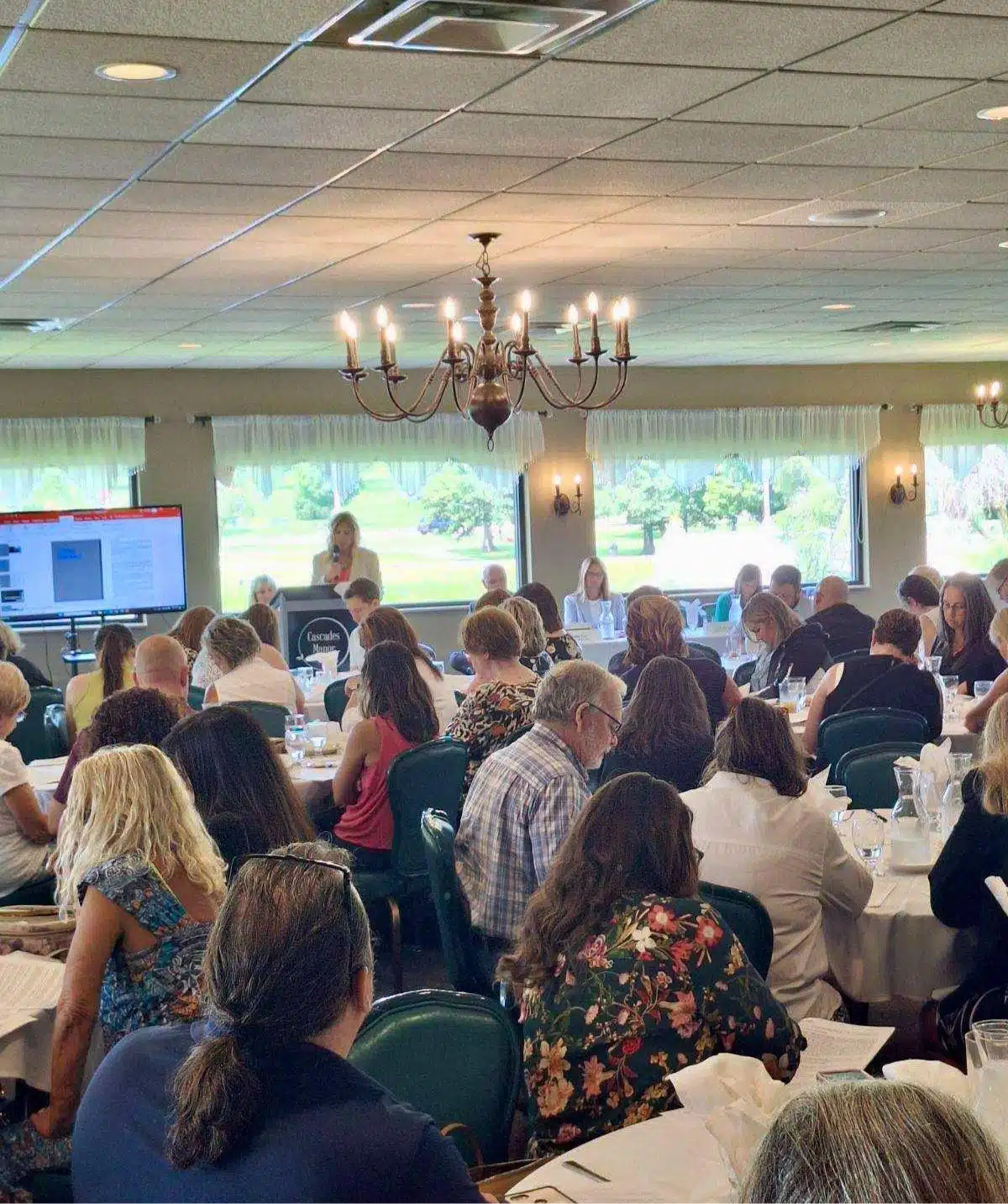 Conference room at Cascades Manor filled with attendees listening to a speaker.