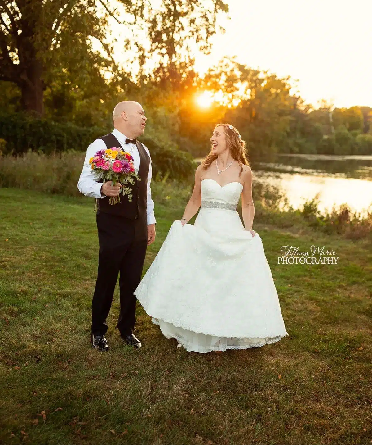 Wedding couple by the river at sunset, celebrating love.