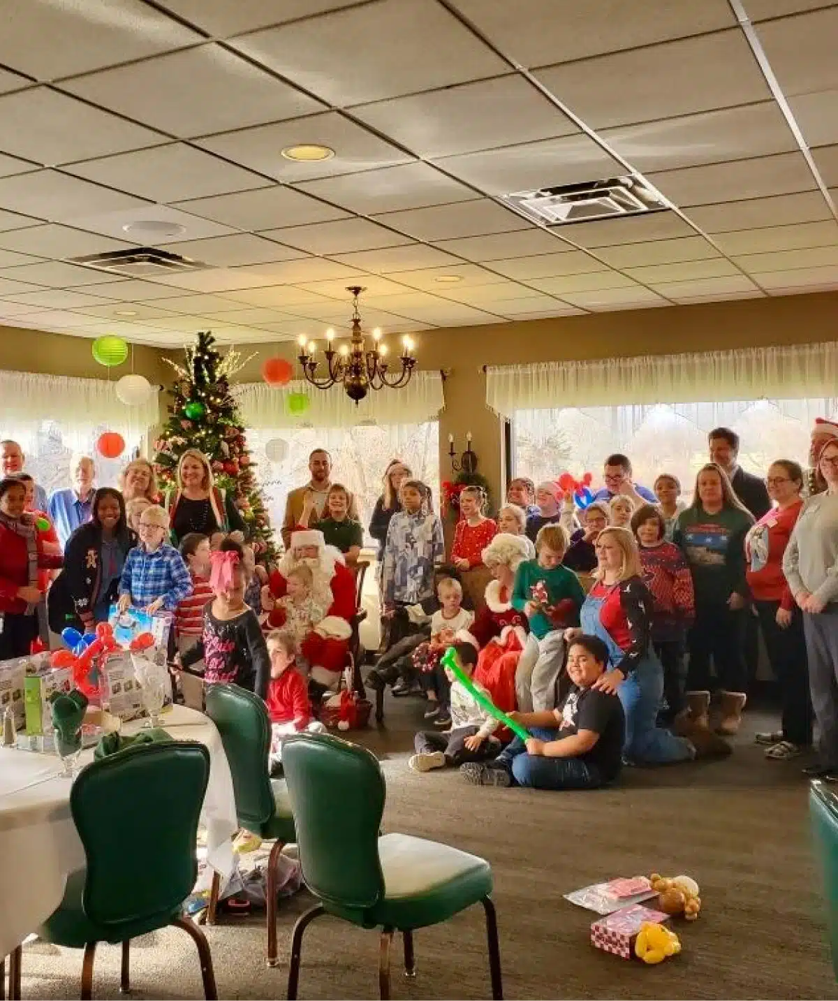 Holiday celebration with families, Christmas tree, and decorations at Cascades Manor.