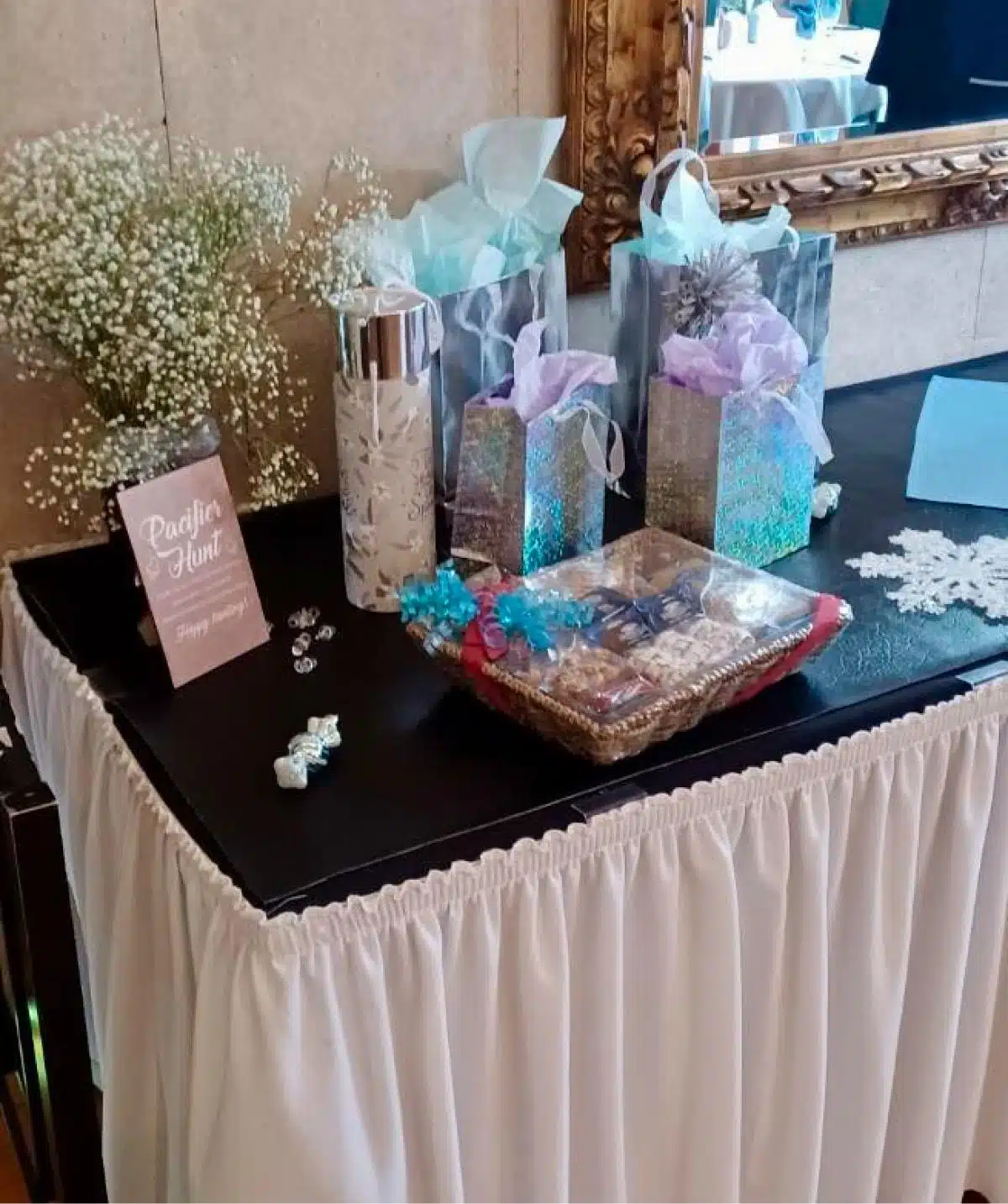 Elegant gift table with wrapped presents, flowers, and decorative items at Cascades Manor.