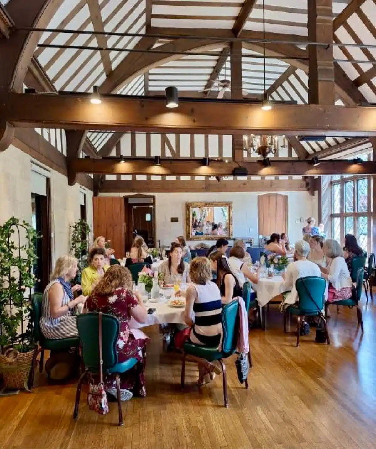 Indoor dining at Cascades Manor with guests enjoying a meal in a rustic, wooden-beamed setting.