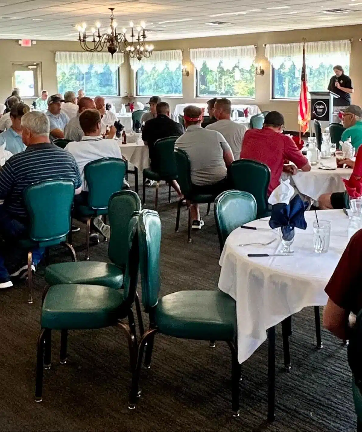 Event room at Cascades Manor filled with attendees listening to a speaker.