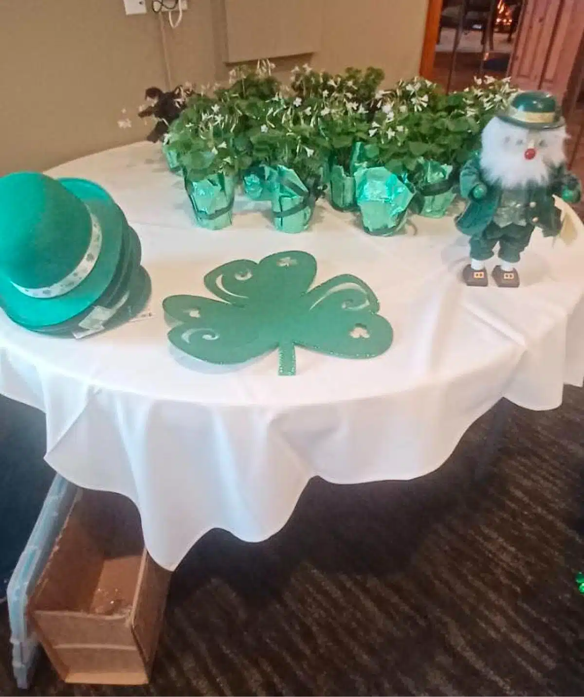 Festive St. Patrick's Day table setup with shamrocks, leprechaun figurine, and green accents.