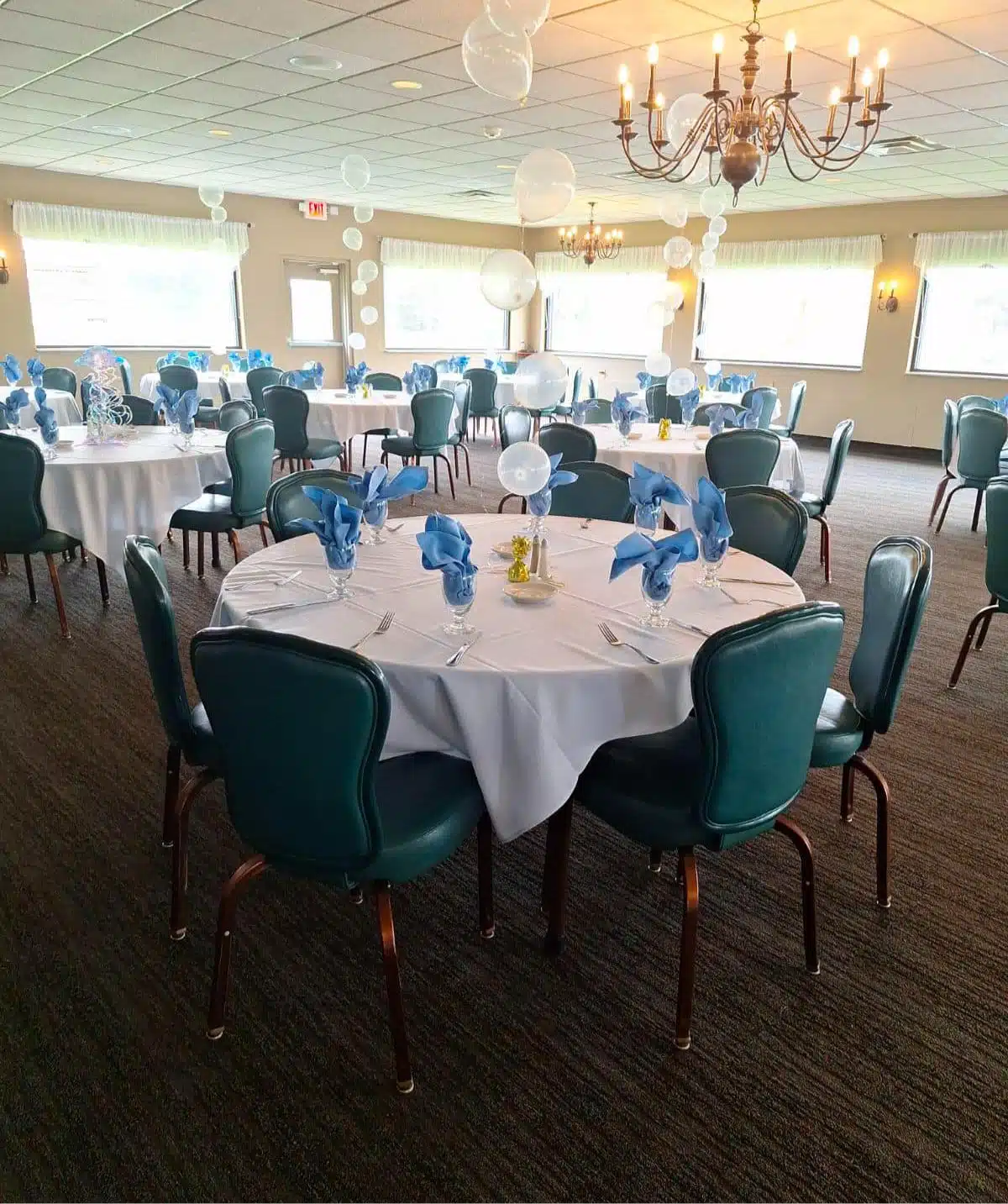 Beautifully decorated banquet hall with round tables and blue accents at Cascades Manor.