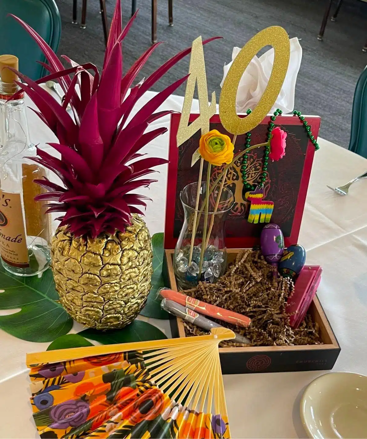 Pineapple-shaped centerpiece with vibrant pink leaves for special events at Cascades Manor.