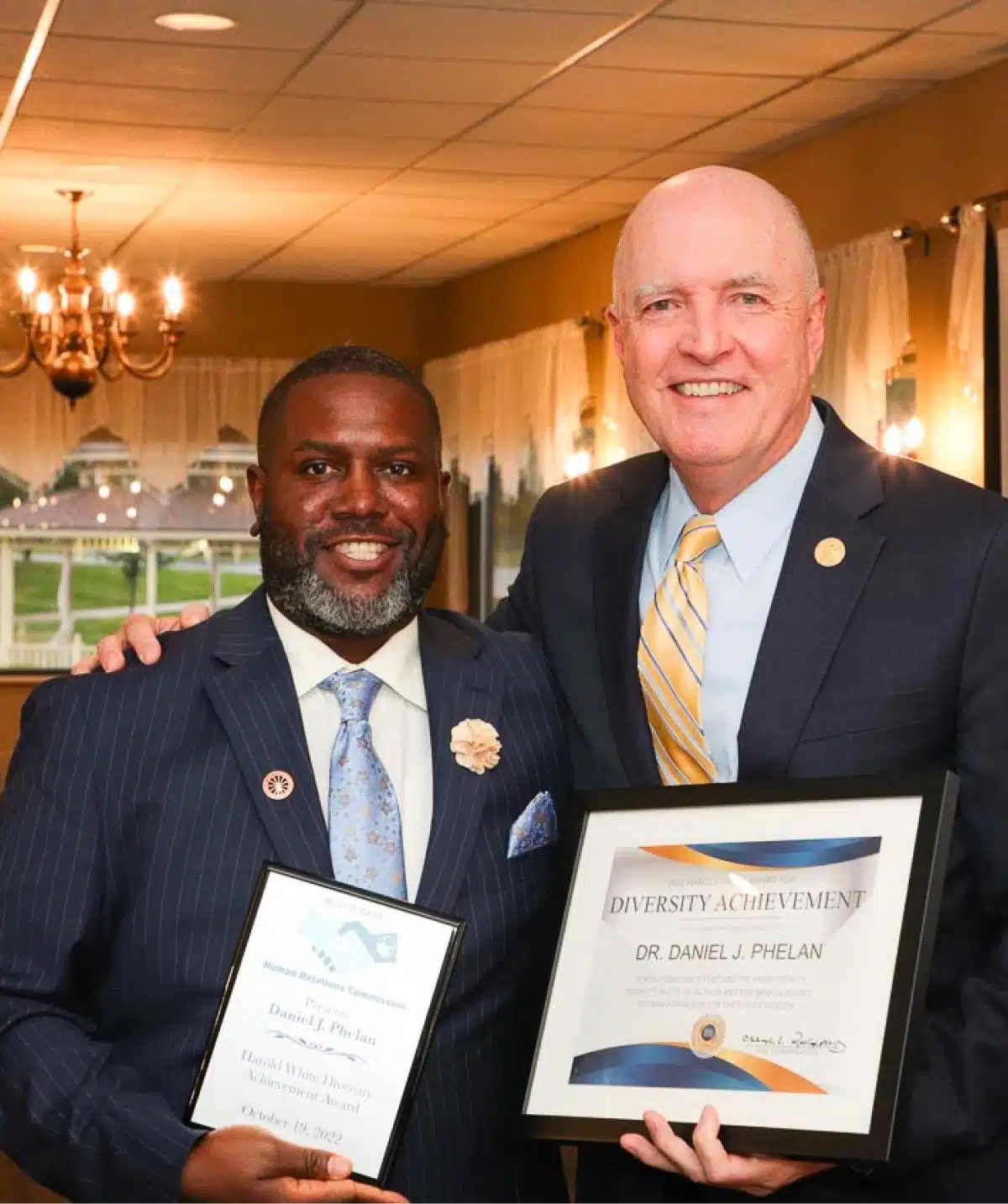 Two men holding awards at Cascades Manor event, celebrating diversity.