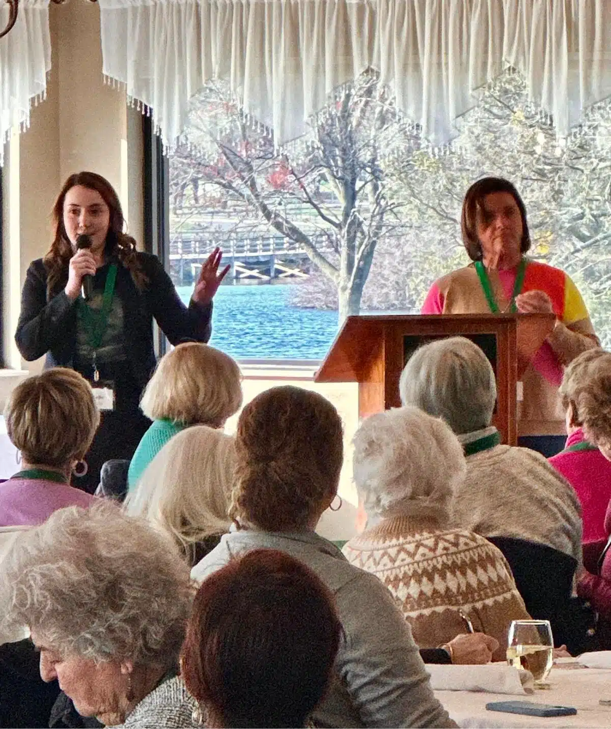 Indoor event at Cascades Manor with speakers and audience.