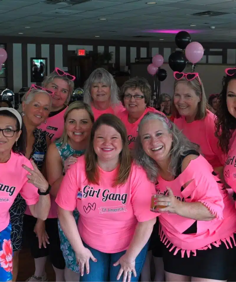 Group of women celebrating at Cascades Manor, Maryland, wearing pink shirts.