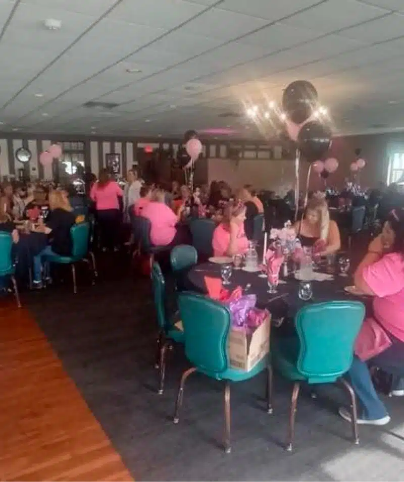 Elegant event at Cascades Manor with guests in pink attire, decorated with balloons and table settin.