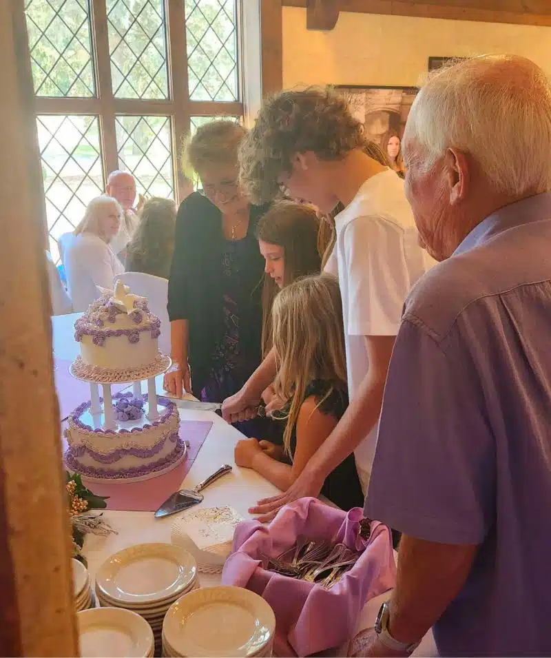 Family gathering at Cascades Manor with cake and guests enjoying a special event.