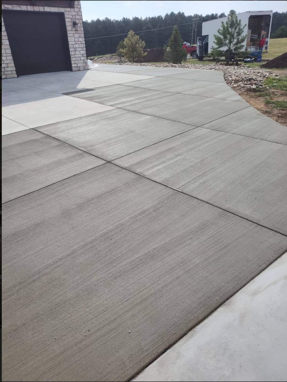 Large broom‑finish concrete driveway panels with saw‑cut joints at a rural Colorado Springs property