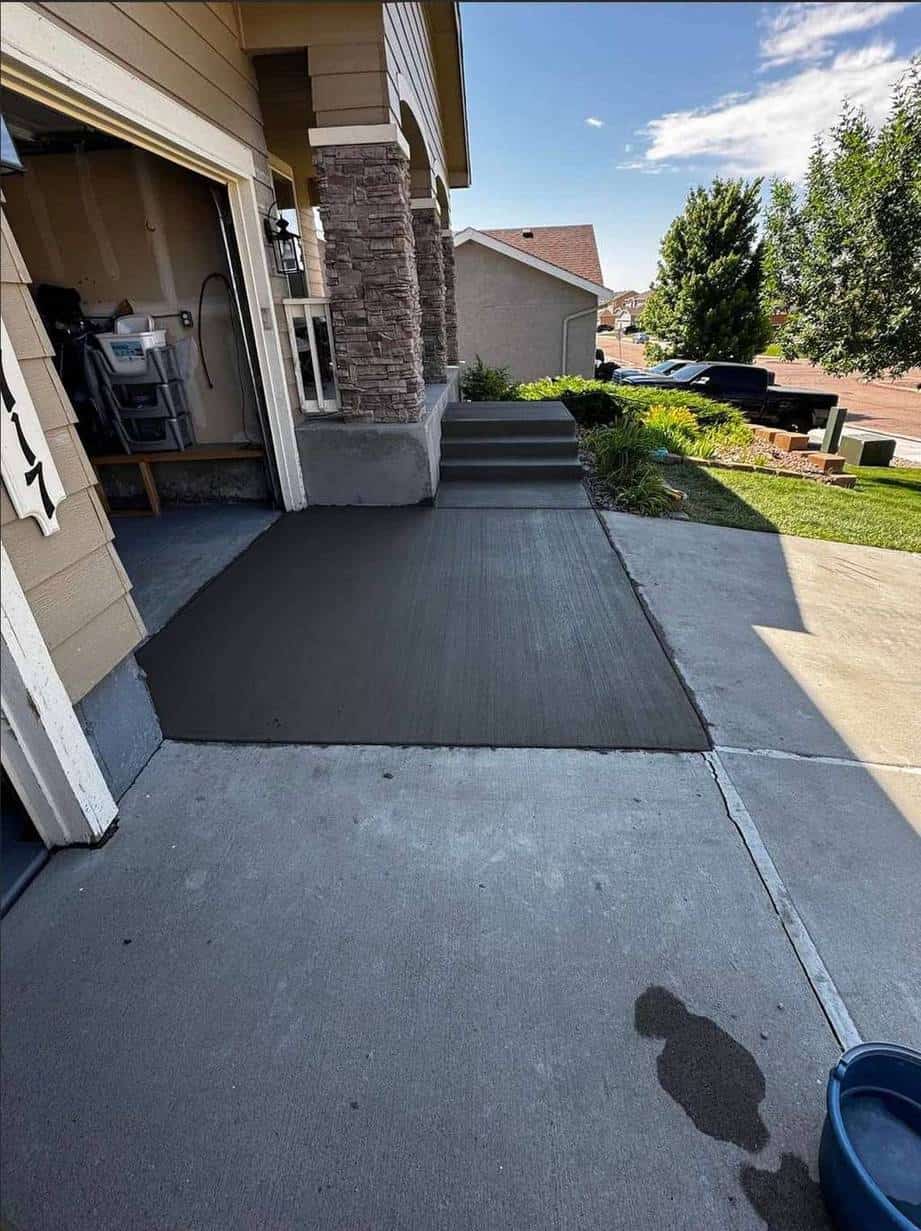 Fresh broom‑finish concrete apron and matching steps connecting driveway to garage entry at a Colorado Springs residence