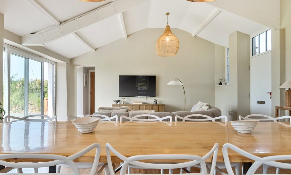 Bright, spacious living room with high vaulted ceilings, large windows, and modern decor at Cornish Secrets.