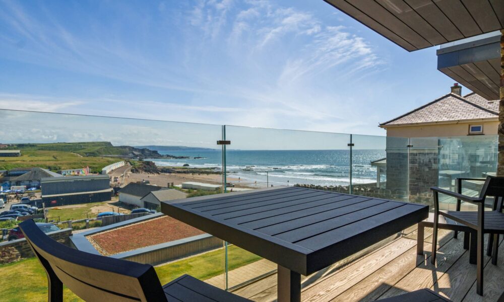 Breathtaking coastal view from a Cornwall seaside accommodation balcony.