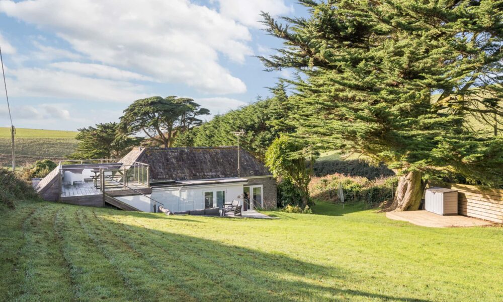 Rustic Cornish cottage with garden and large trees, peaceful countryside retreat in Cornwall.