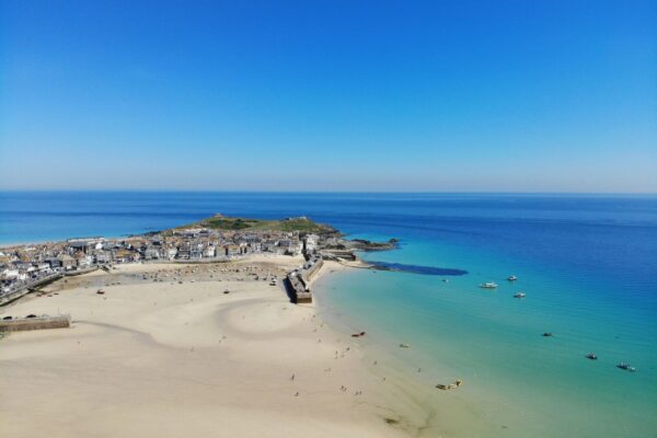 St Ives Beach with golden sands and vibrant seaside townscape in Cornwall.