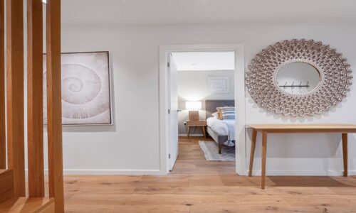 Coastal-inspired bedroom with wooden furniture and natural decor elements in Cornwall.