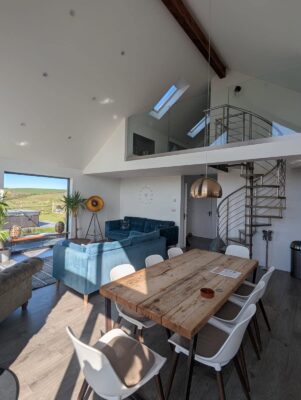 Bright spacious open-plan living and dining area with modern decor in Cornwall cottages.