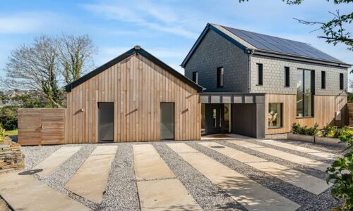 Cornish Secrets coastal retreat with modern and rustic design, solar panels, and landscaped garden.