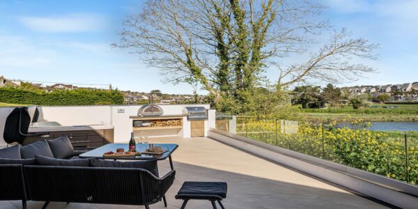 Riverside terrace at Cornish Secrets with outdoor seating and scenic views of the river and surround.